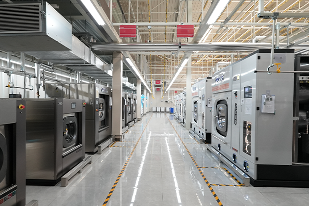 Full-scale industrial laundry plant setup showing heavy-duty commercial dry cleaning and wet washing machinery